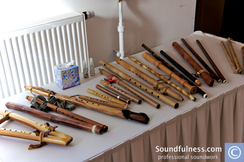 Table lined with wooden Native American style flutes and rattles