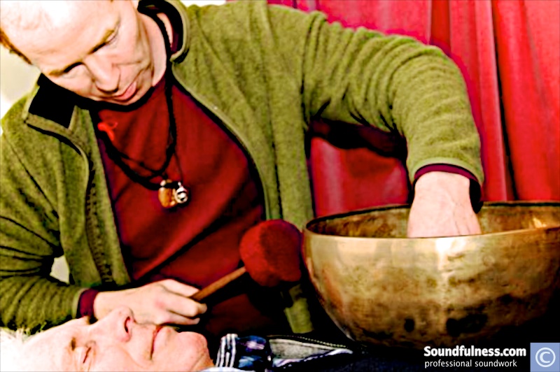 Coen holding a large singing bowl above a client's head during a wellness session