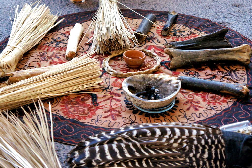 Close-up altar with bones, feathers, seed brushes and clay bowl
