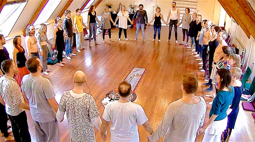 Wide circle of participants holding hands in a Tribal ceremony