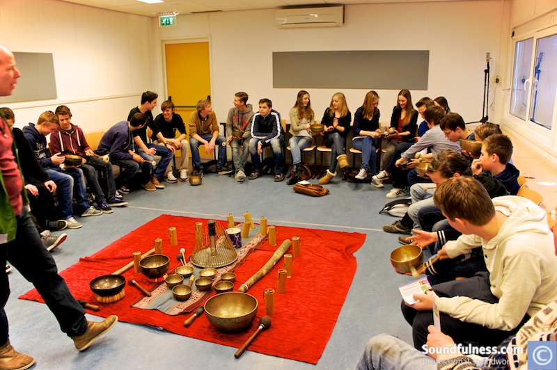 Teenagers seated in a full circle around an instrument altar during a school session