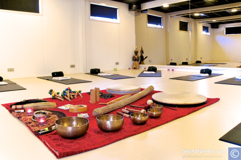 Wellness studio set with mats, bolsters and a central altar of bowls and shakers