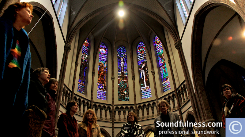 Group standing beneath the stained-glass apse of a Nijmegen church