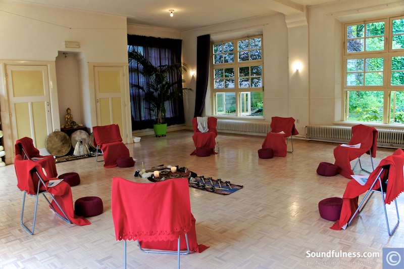 Empty training room set with red-draped chairs around a central altar