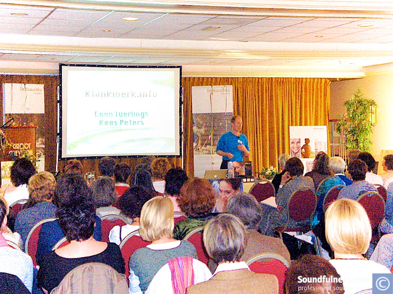 Coen presenting Klankwerk.info to a large seated audience in a hotel ballroom