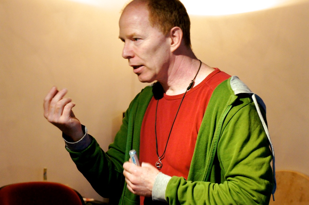 Portrait of Coen speaking with a lavalier microphone in warm light