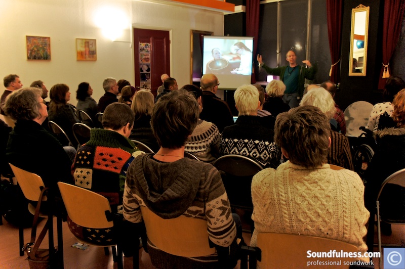 Coen presenting a Soundfulness video to a full seated audience in a community hall