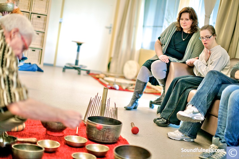 Care group sound session with clients on a couch and altar of bowls and chimes on the floor
