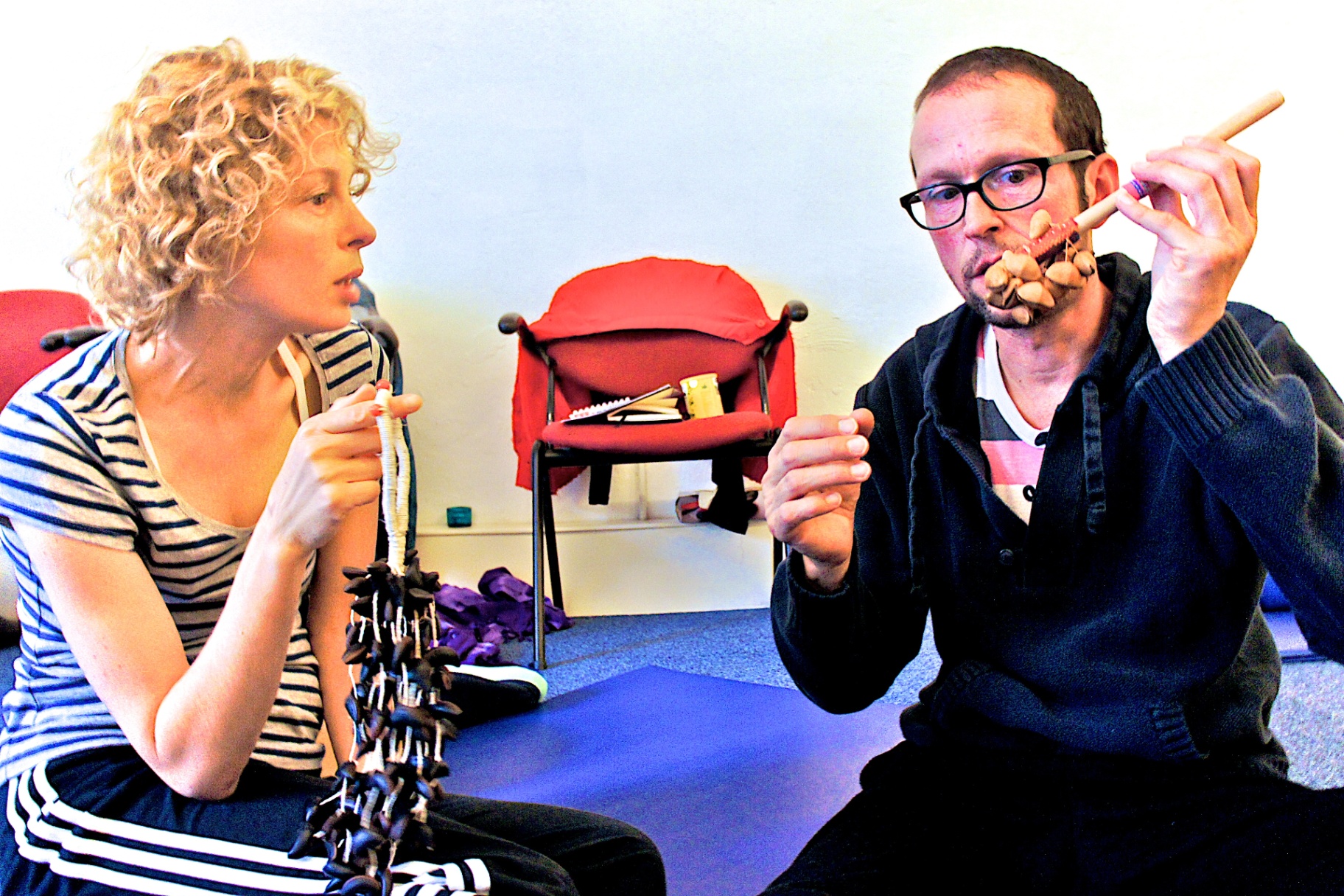 Coen showing seed rattles to a participant in a one-on-one instrument session