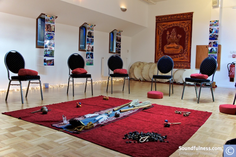 Organisational session room with chairs, cushions and central altar beneath a Shiva tapestry