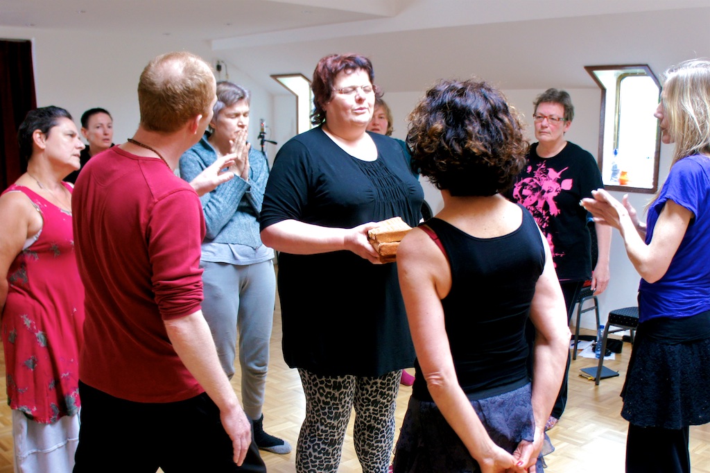 Participants passing a bundled offering in a standing circle
